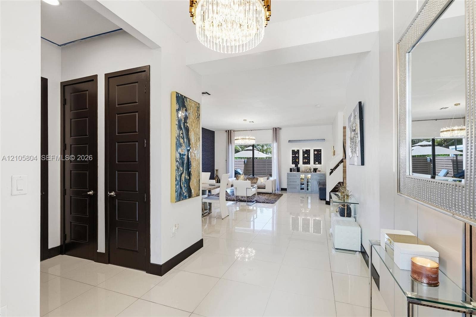15932 SW 136th Way, Miami, FL 33196 Polished porcelain tile flooring, dark-toned six-panel interior doors, and a multi-tiered crystal drum chandelier