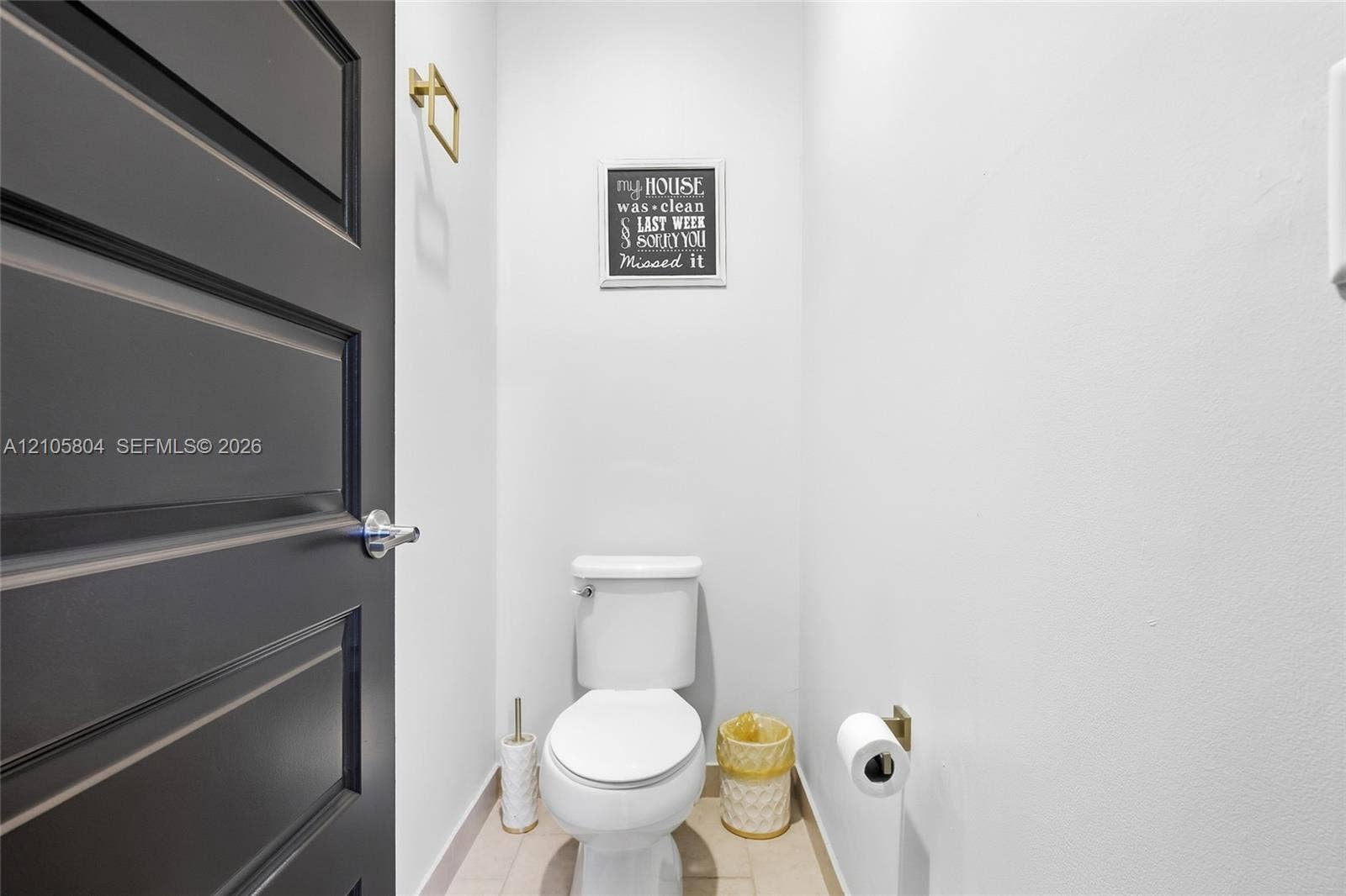 15932 SW 136th Way, Miami, FL 33196 Powder room featuring a matte black paneled door, gold-tone hardware, and a high-profile toilet