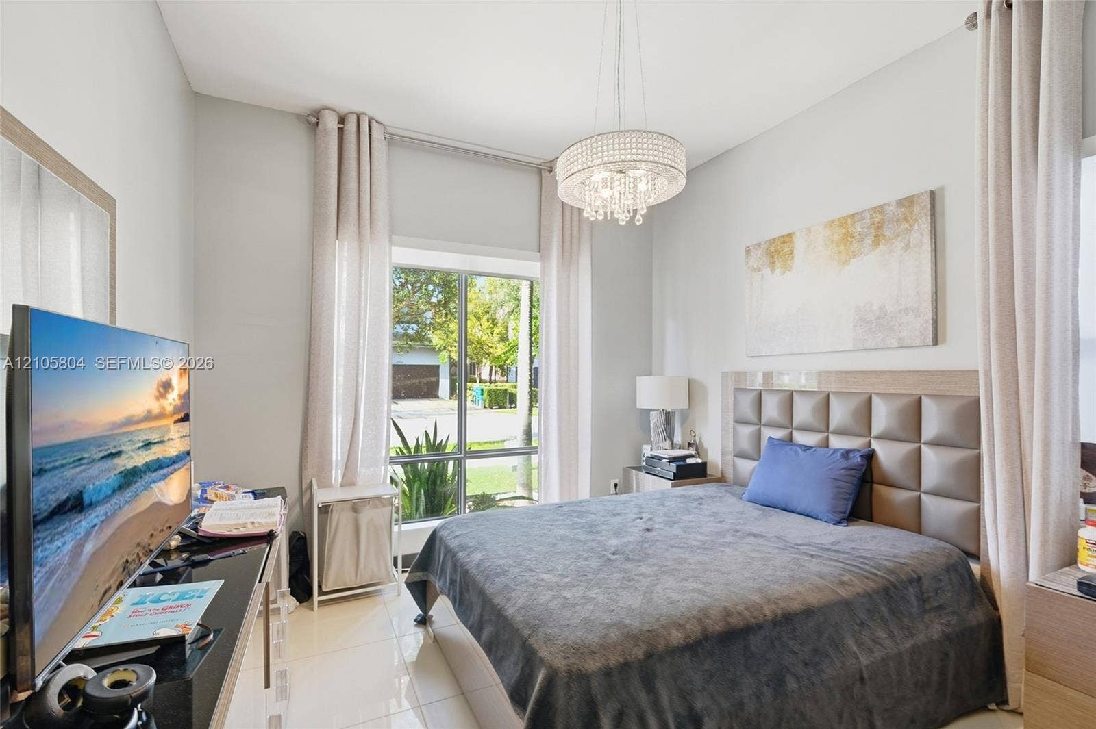 15932 SW 136th Way, Miami, FL 33196 High-ceilinged room featuring oversized window panels, glossy tile flooring, and a crystal-accented chandelier fixture