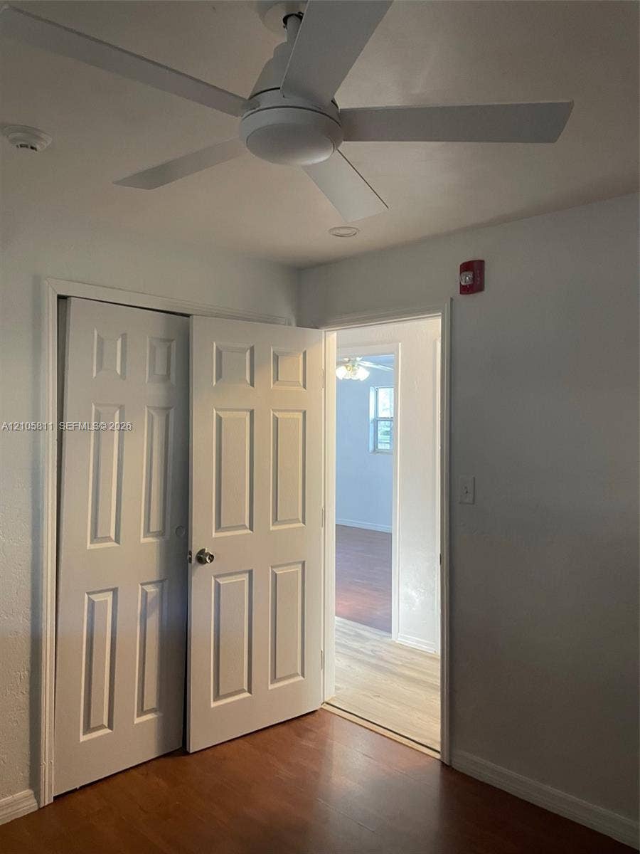 Room featuring a white ceiling fan and a multi-panel interior door providing entry to a closet