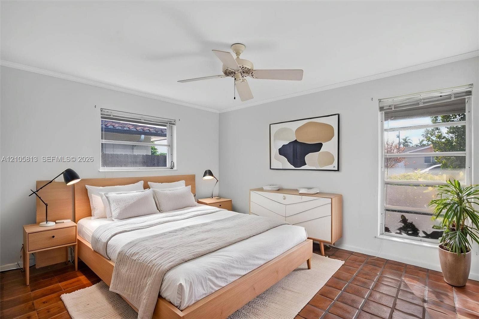 Room featuring horizontal-pane windows, terra cotta tile flooring, and a ceiling-mounted fan