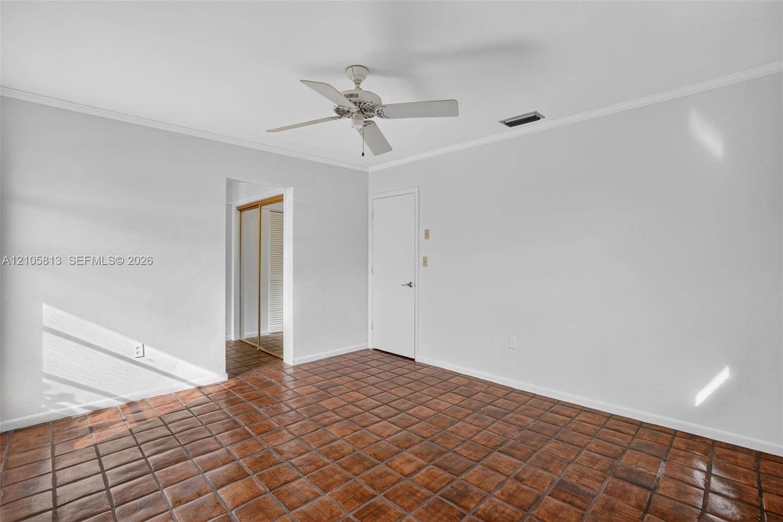 Room featuring clay tile flooring, a neutral wall finish, and a ceiling fan with integrated lighting