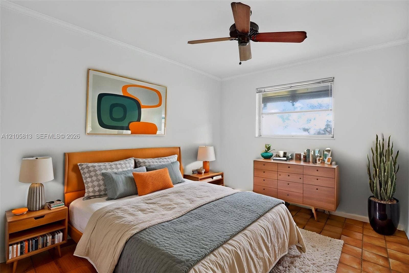 Bedroom featuring terra-cotta tile flooring, a horizontal single-hung window, and a ceiling fan with integrated lighting