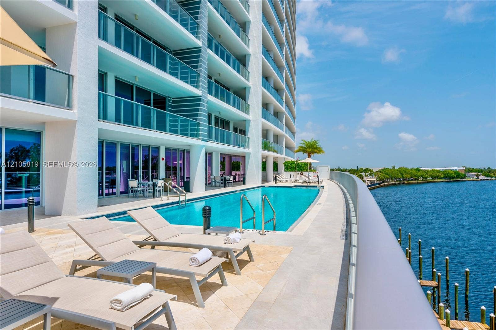 1180 N Federal Highway, #810, Fort Lauderdale, FL 33304 Heated Pool Overlooking Middle River. Waterfront terrace featuring a rectangular swimming pool, stone-tile decking, and glass-railing balconies