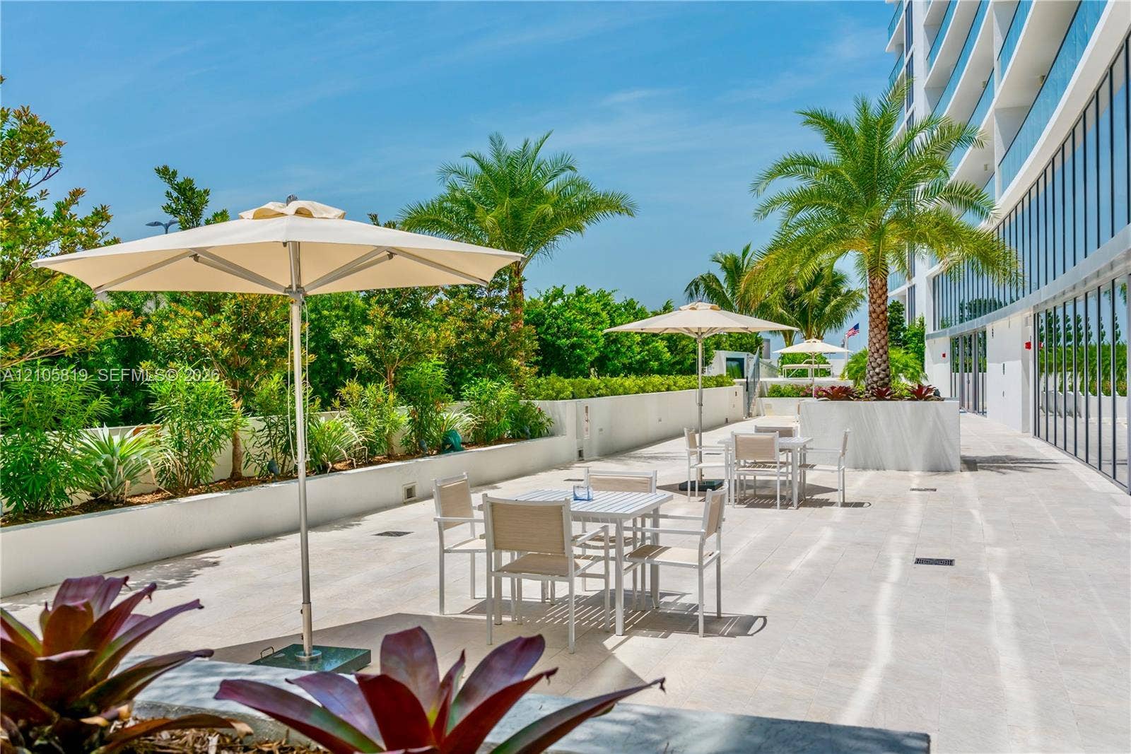 1180 N Federal Highway, #810, Fort Lauderdale, FL 33304 Outdoor terrace featuring stone-finish flooring, integrated concrete planters, and mature palm landscaping