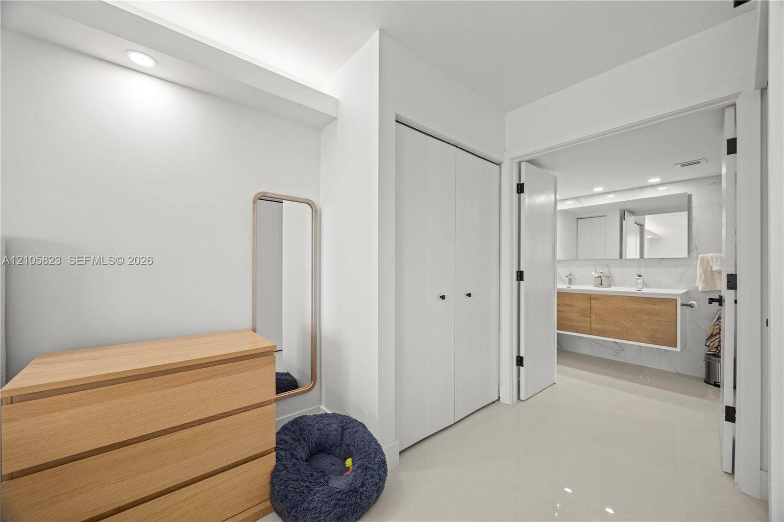 Recessed lighting, double-door closet storage, and large-format tile flooring