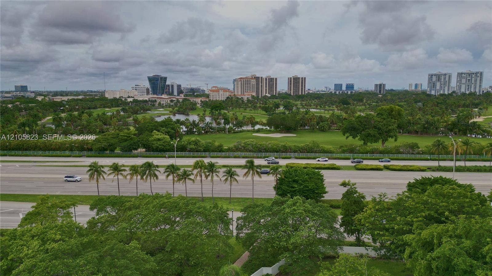 Aerial perspective featuring expansive green space, mature canopy trees, and an open golf course landscape