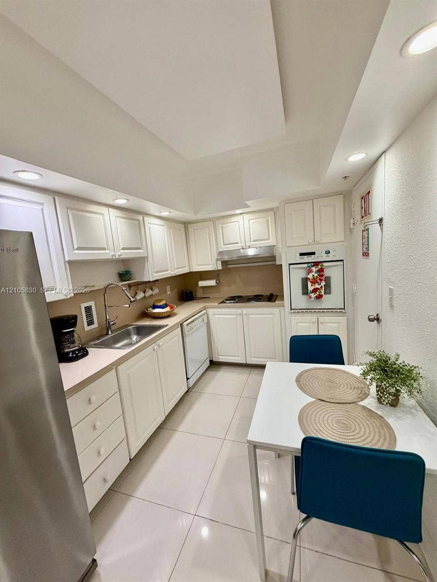 4001 S Ocean Drive, #14F, Hollywood, Hollywood, FL 33019 Kitchen featuring white cabinetry, stainless steel refrigerator, built-in oven, gas cooktop, and tile flooring