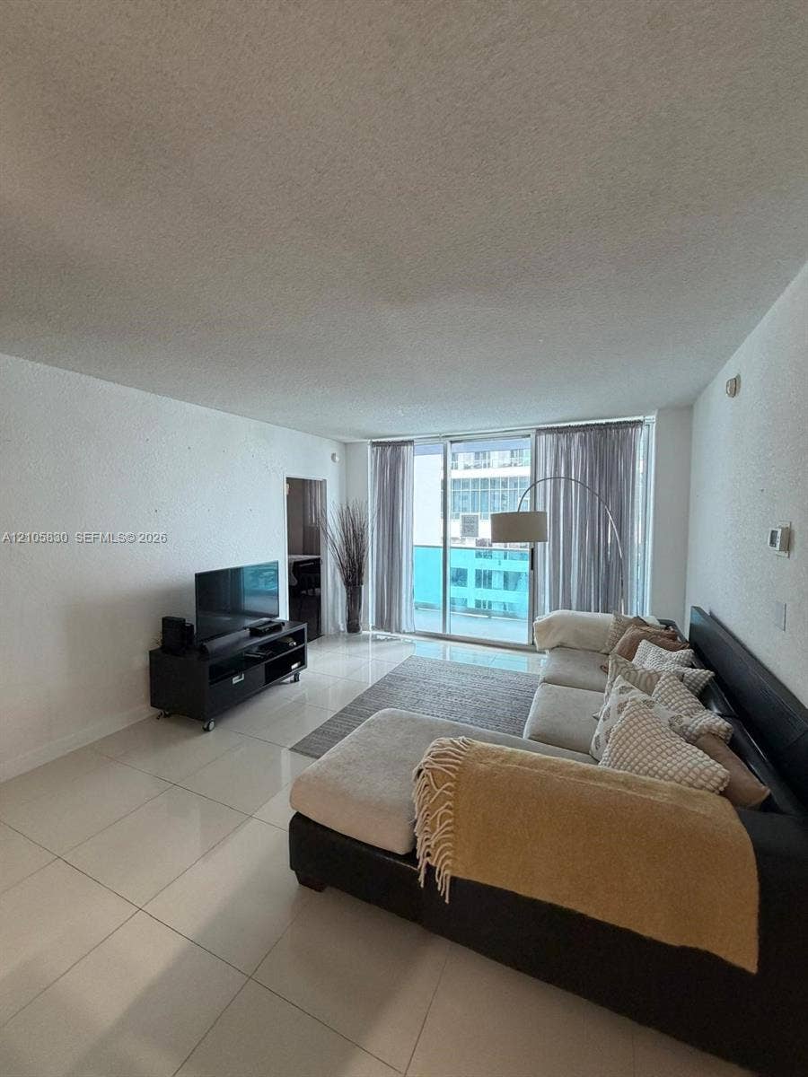 4001 S Ocean Drive, #14F, Hollywood, Hollywood, FL 33019 Large format porcelain tile flooring, textured walls, and floor-to-ceiling sliding glass doors opening to a balcony