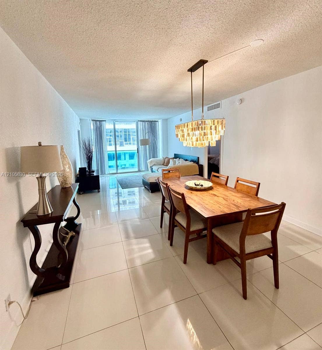 4001 S Ocean Drive, #14F, Hollywood, Hollywood, FL 33019 Large-format tile flooring, rectangular pendant light fixture with tiered glass elements, and floor-to-ceiling glass doors