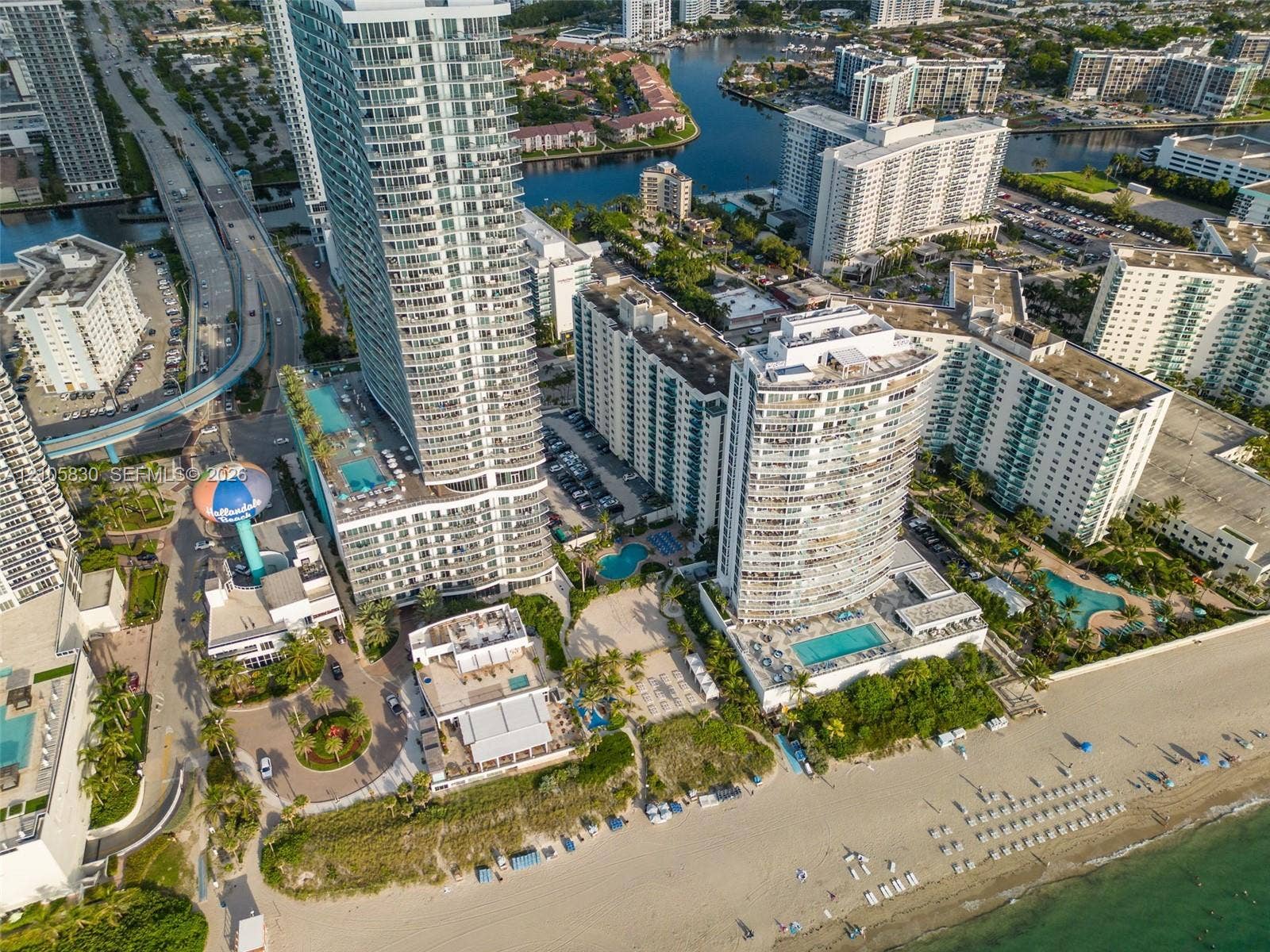 4001 S Ocean Drive, #14F, Hollywood, Hollywood, FL 33019 Aerial perspective of high-rise structures featuring integrated outdoor swimming pools, multi-level parking facilities, and direct shoreline access