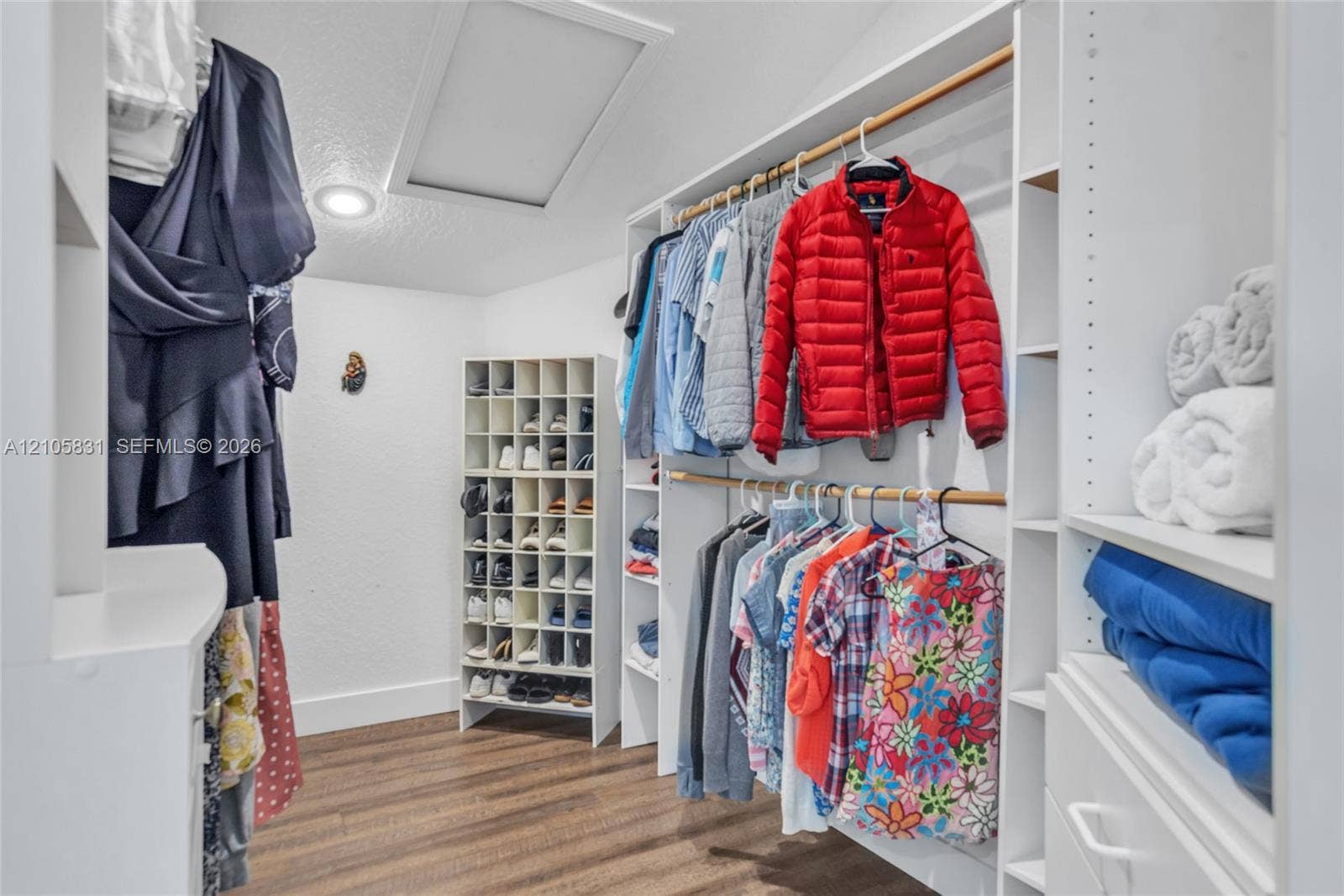 15612 SW 16th Court, Pembroke Pines, FL 33027 Walk-in closet featuring white built-in shelving, integrated shoe cubbies, wood-finish flooring, and recessed lighting