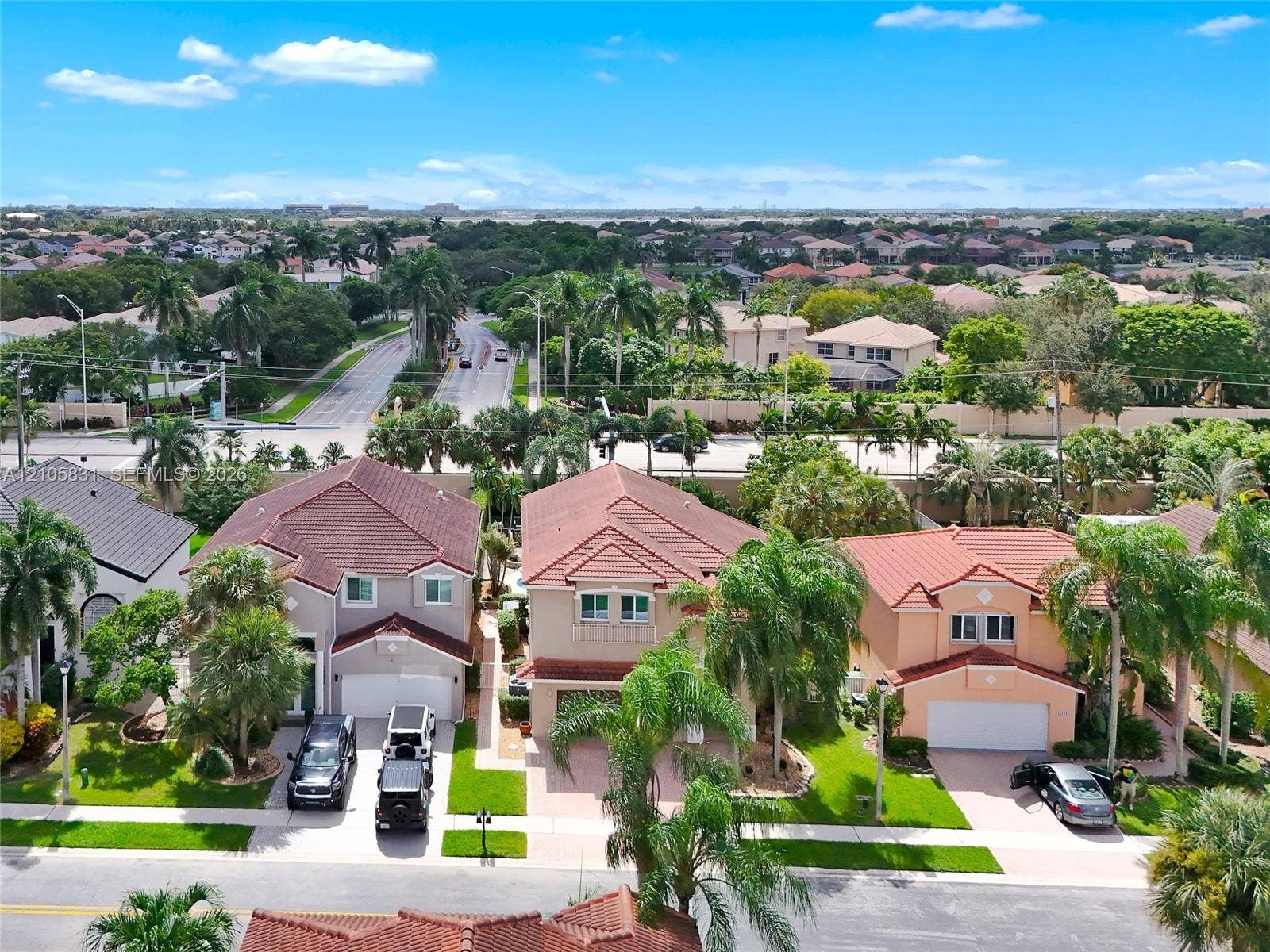15612 SW 16th Court, Pembroke Pines, FL 33027 Aerial perspective of a multi-story residential community featuring tile roofs, paved driveways, attached garages, and established tropical landscaping