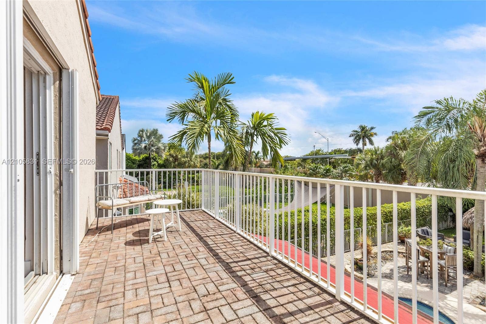 15612 SW 16th Court, Pembroke Pines, FL 33027 Elevated balcony featuring brick paver flooring, white metal railing, and sliding glass door access