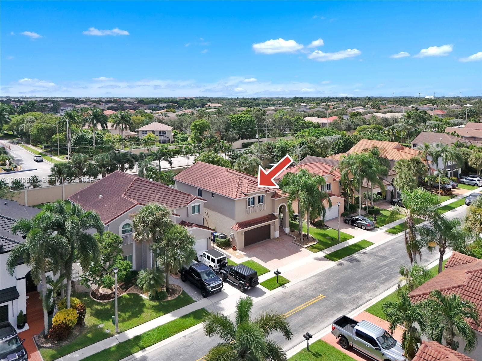 15612 SW 16th Court, Pembroke Pines, FL 33027 Two-story residence featuring a tile roof, paved driveway, attached garage, and mature palm landscaping
