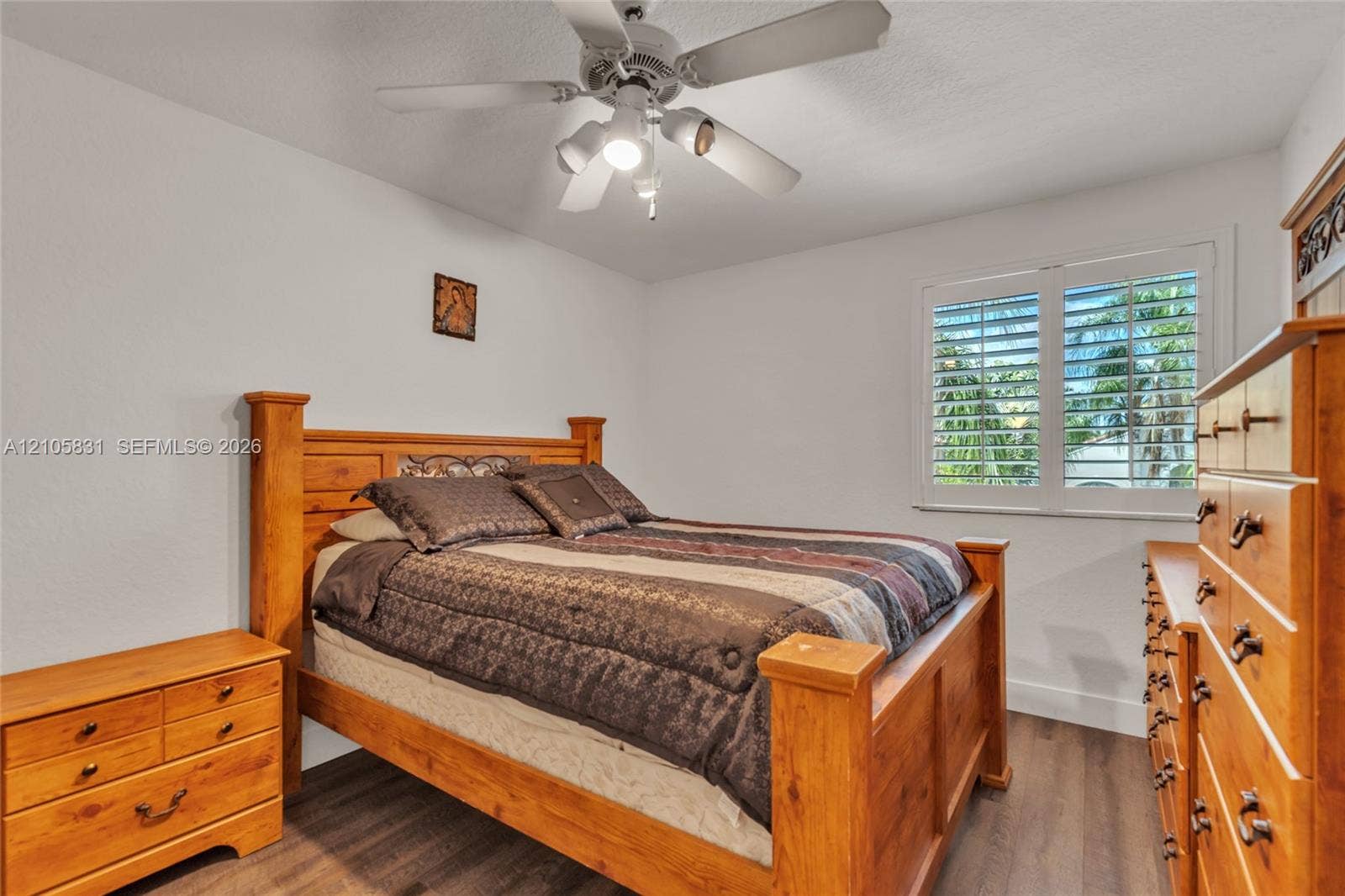15612 SW 16th Court, Pembroke Pines, FL 33027 Wood-finish flooring, white plantation shutters, and a multi-light ceiling fan