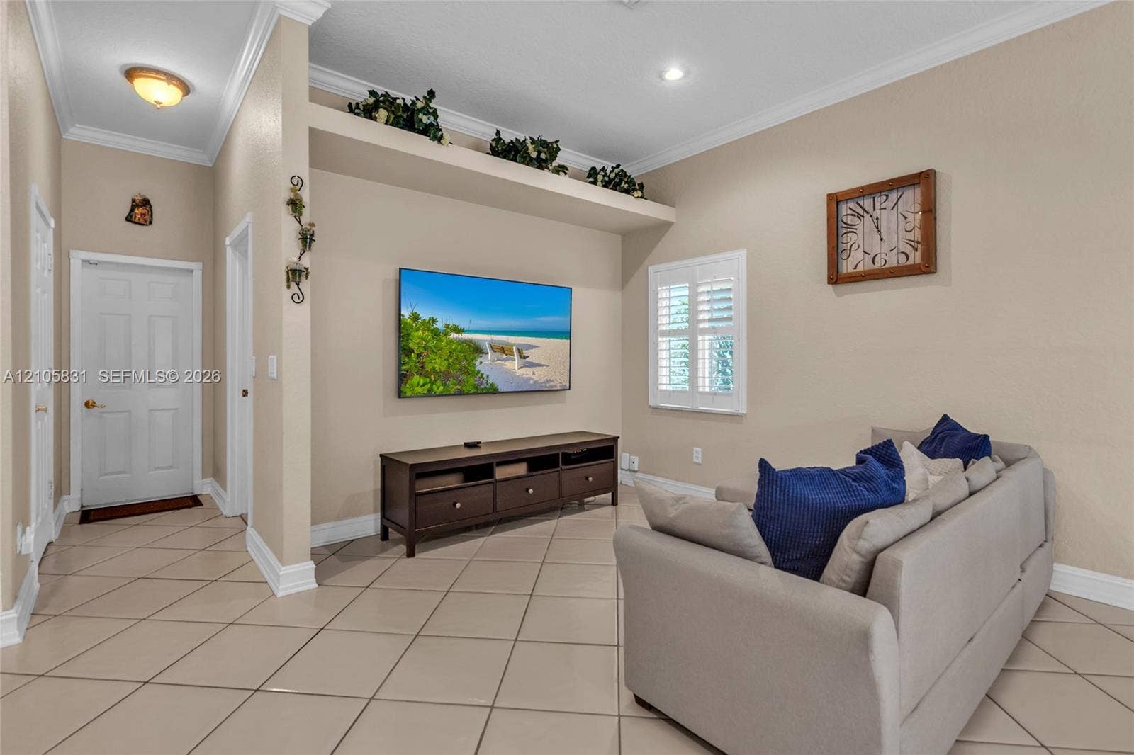 15612 SW 16th Court, Pembroke Pines, FL 33027 Interior space featuring large-format tile flooring, crown molding, built-in recessed display niche, and plantation shutters