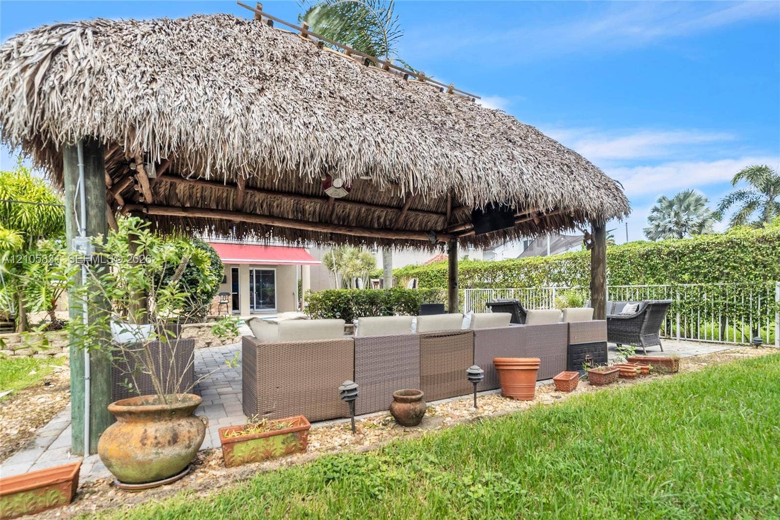 15612 SW 16th Court, Pembroke Pines, FL 33027 Outdoor thatched-roof tiki hut featuring post-and-beam construction, recessed ceiling fan, and paved stone patio flooring