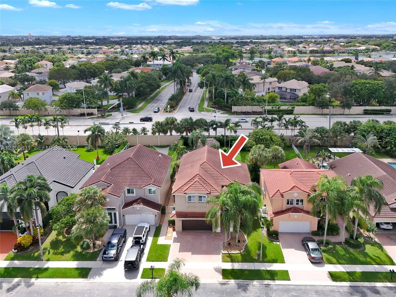 15612 SW 16th Court, Pembroke Pines, FL 33027 Two-story residence featuring a tile roof, multi-car garage, paved driveway, and established palm landscaping