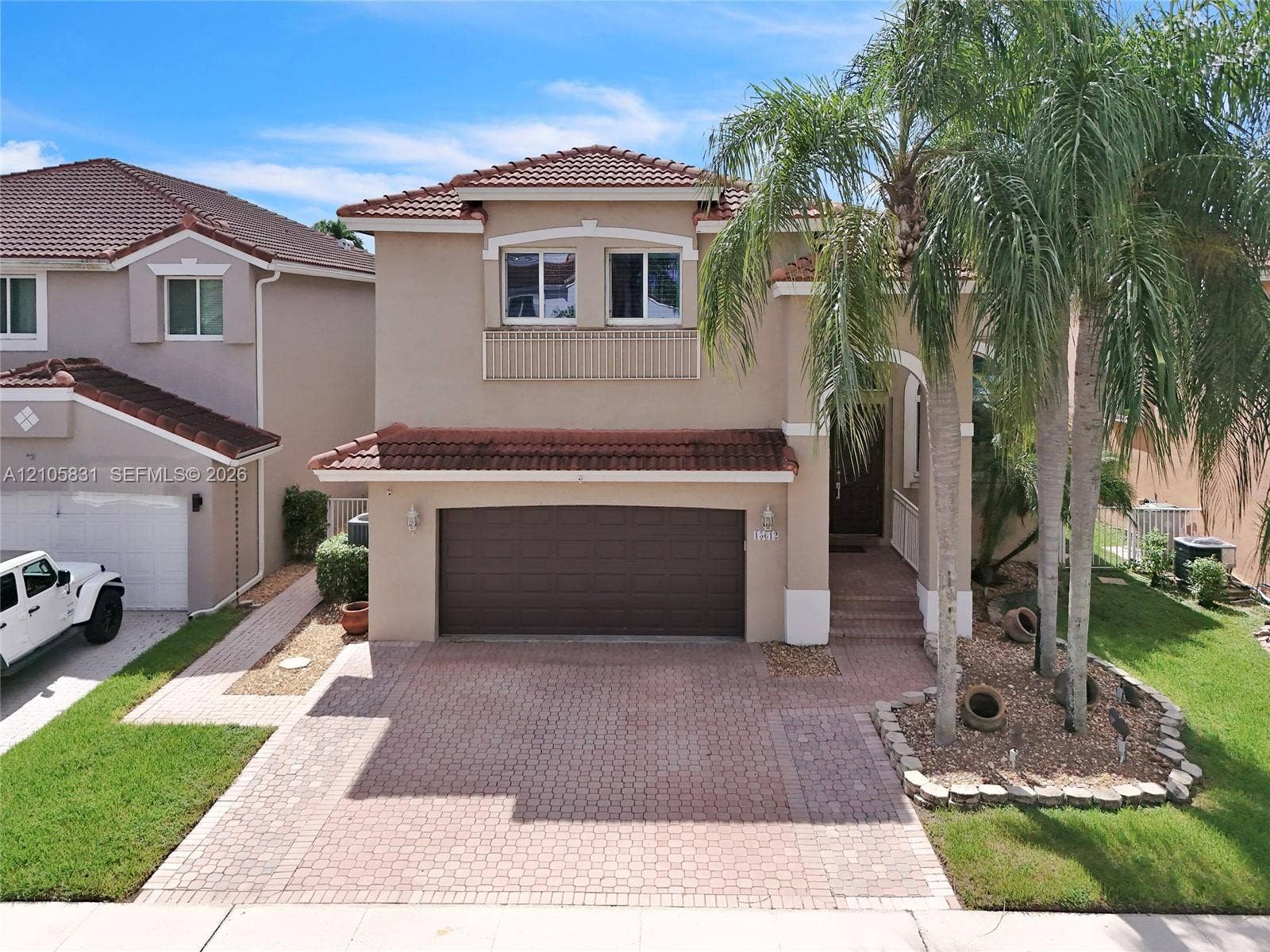 15612 SW 16th Court, Pembroke Pines, FL 33027 Two-story exterior featuring a stucco facade, red tile roof, two-car garage, and a brick-paver driveway