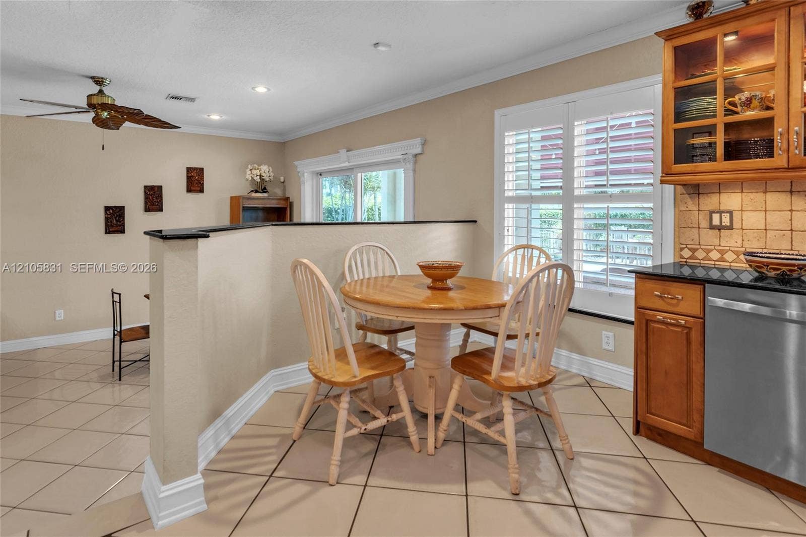 15612 SW 16th Court, Pembroke Pines, FL 33027 Kitchen area featuring wood cabinetry, stone countertops, square-tiled backsplash, plantation shutters, and large-format tile flooring