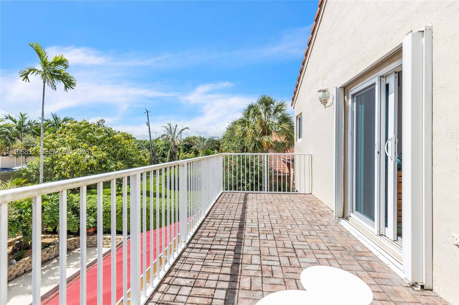 15612 SW 16th Court, Pembroke Pines, FL 33027 Second-story balcony featuring brick-paver flooring, white metal railing, and sliding glass door entry