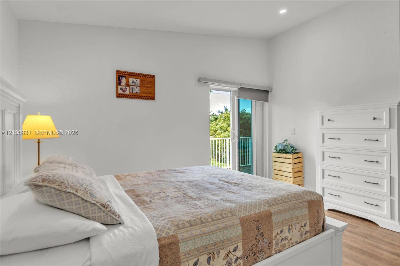 15612 SW 16th Court, Pembroke Pines, FL 33027 High-ceilinged room featuring wood-finish flooring, white built-in cabinetry, and a glass-paneled door opening to a balcony