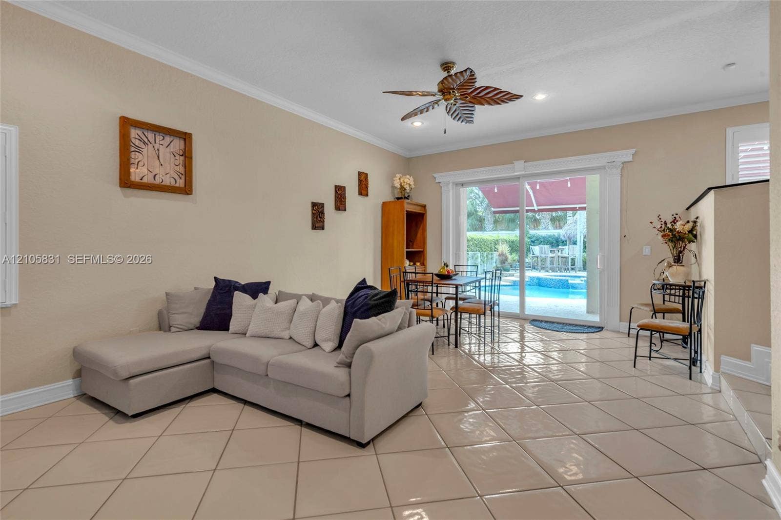 15612 SW 16th Court, Pembroke Pines, FL 33027 Large-format tile flooring, decorative ceiling fan with blade accents, and sliding glass doors featuring detailed trim molding