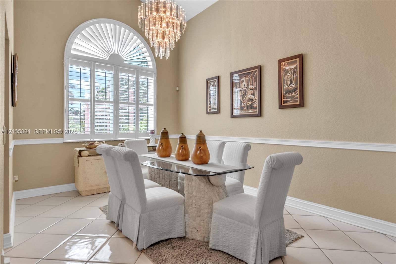 15612 SW 16th Court, Pembroke Pines, FL 33027 High-ceilinged room featuring an arched window with plantation shutters, tile flooring, crown molding, and a tiered crystal chandelier