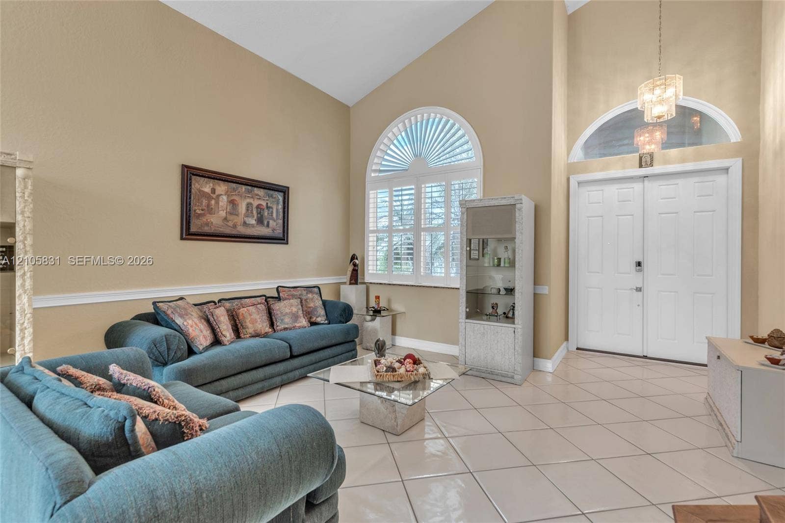 15612 SW 16th Court, Pembroke Pines, FL 33027 Vaulted ceilings featuring a chandelier, large arched window with custom shutters, transom window, and ceramic tile flooring
