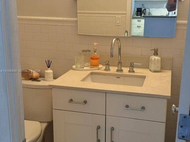1400 S Ocean Drive, #1503, Hollywood, Hollywood, FL 33019 White vanity with a neutral solid-surface countertop, undermount sink, chrome gooseneck faucet, and white subway tile wall backsplash