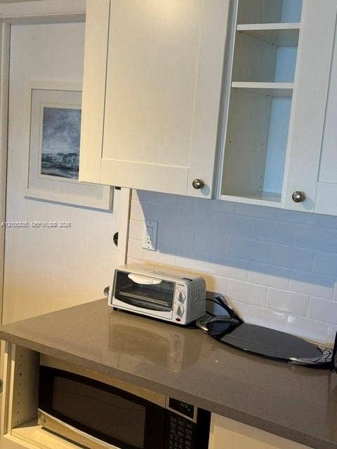 1400 S Ocean Drive, #1503, Hollywood, Hollywood, FL 33019 White shaker-style cabinetry, neutral-toned solid surface countertop, white subway tile backsplash, and built-in microwave