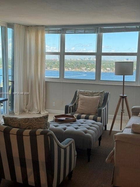 1400 S Ocean Drive, #1503, Hollywood, Hollywood, FL 33019 Floor-to-ceiling windows featuring panoramic water and cityscape scenery, sliding glass door with access to a balcony, and neutral tile flooring