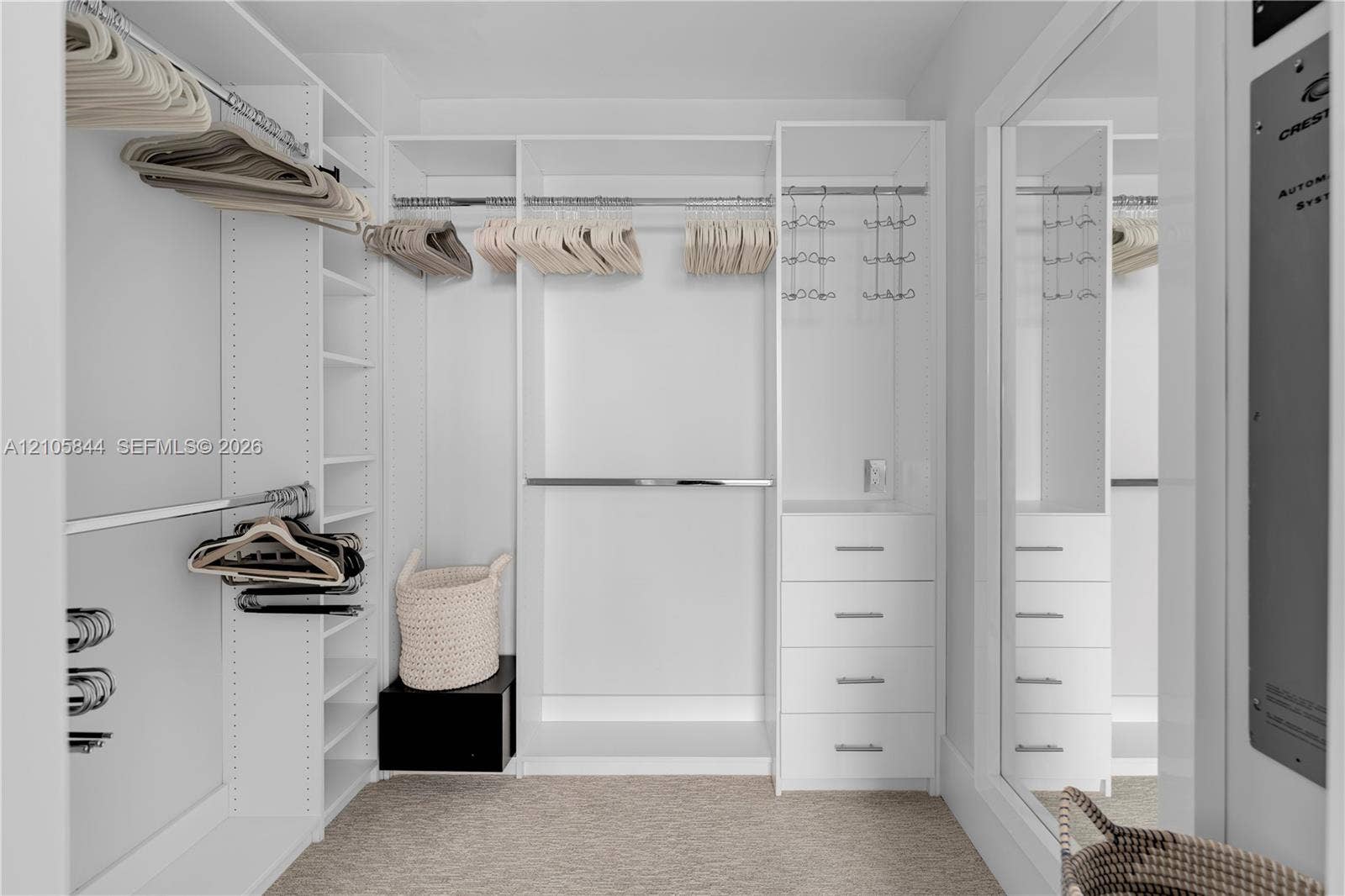 Bal Harbour, Bal Harbour, FL 33154 Walk-in closet featuring white custom built-in cabinetry, floor-to-ceiling shelving, multiple chrome hanging rods, and a four-drawer storage unit