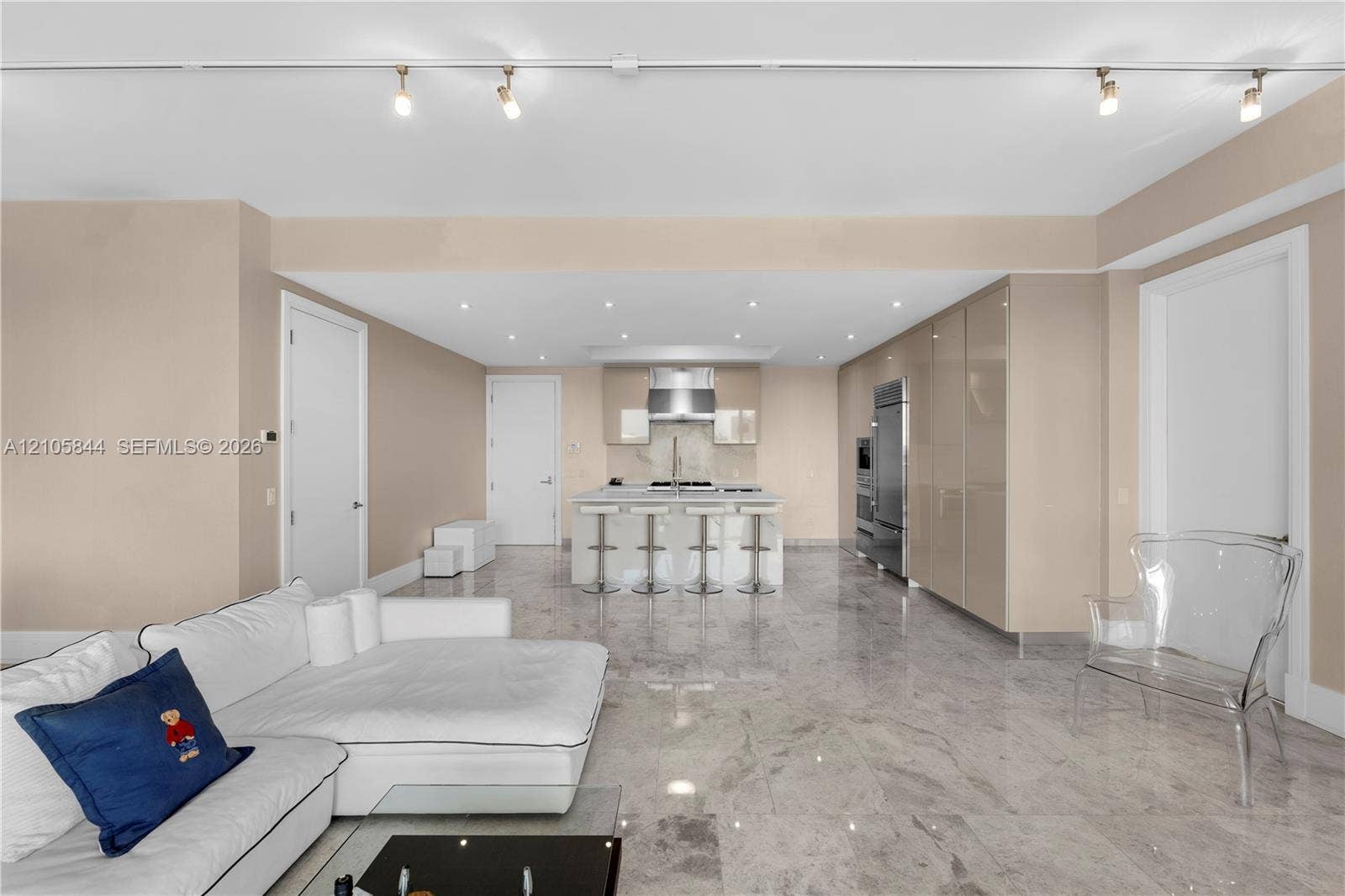 Bal Harbour, Bal Harbour, FL 33154 Kitchen featuring high-gloss cabinetry, a stone-topped island with a stainless steel range hood, stone flooring, and adjustable track lighting