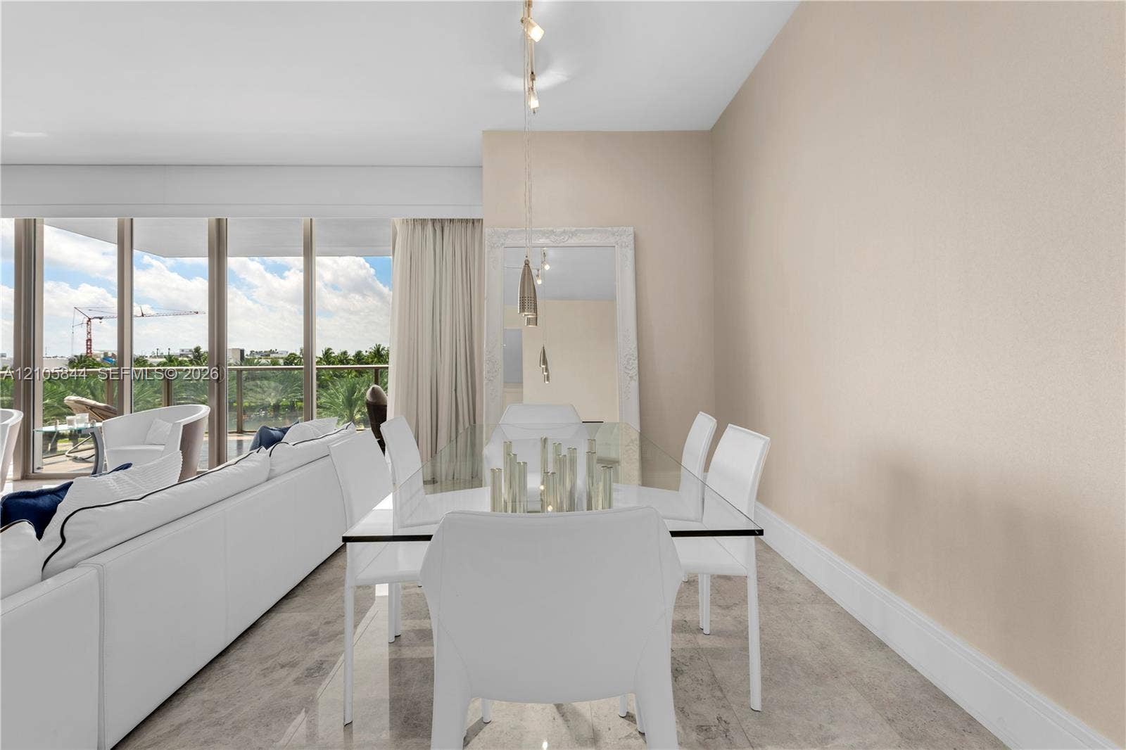 Bal Harbour, Bal Harbour, FL 33154 Open-concept space featuring floor-to-ceiling windows, natural stone flooring, and suspended pendant lighting
