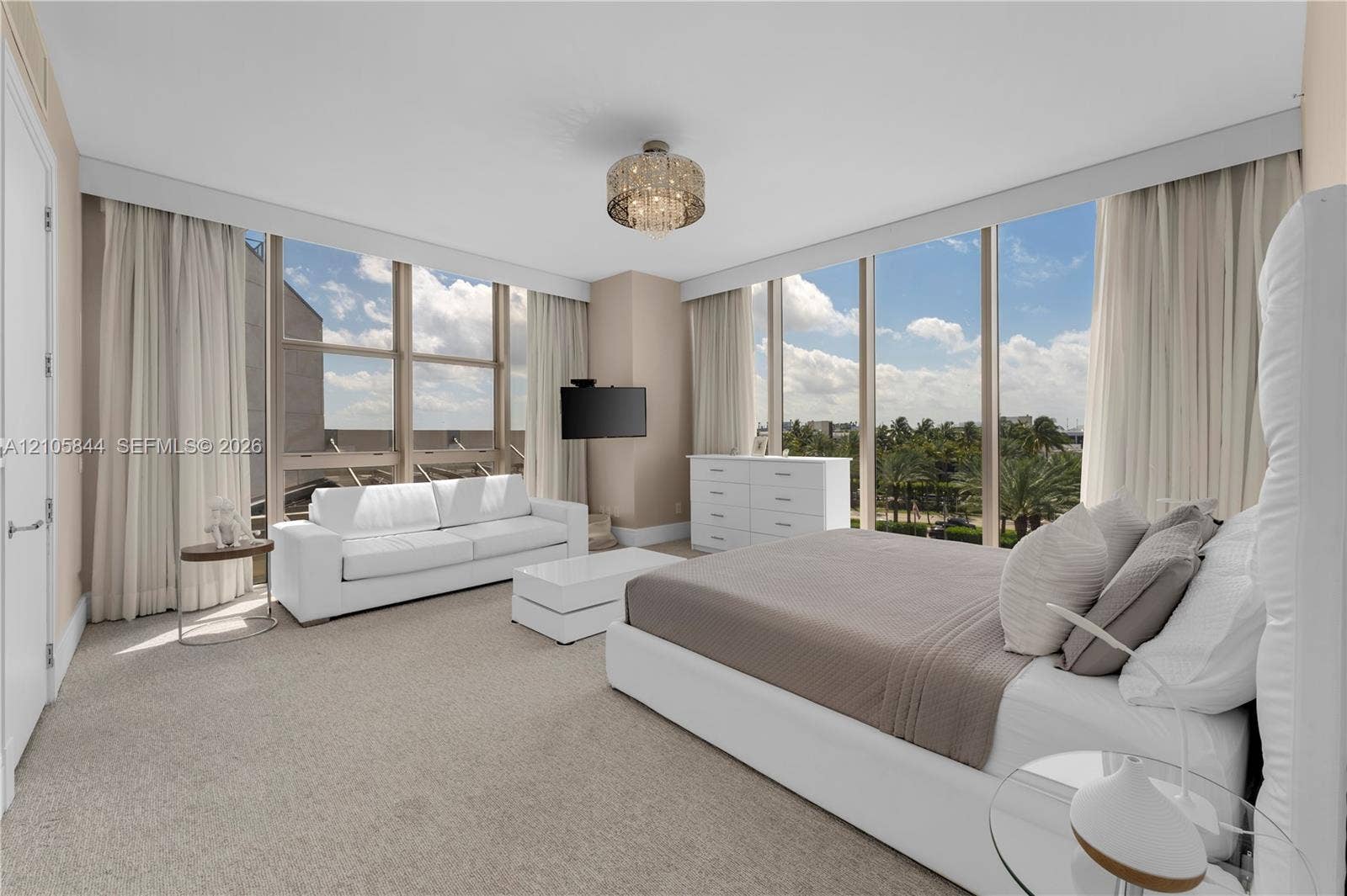 Bal Harbour, Bal Harbour, FL 33154 Floor-to-ceiling windows, neutral carpeting, crystal-accented flush mount lighting, and custom-fit window treatments