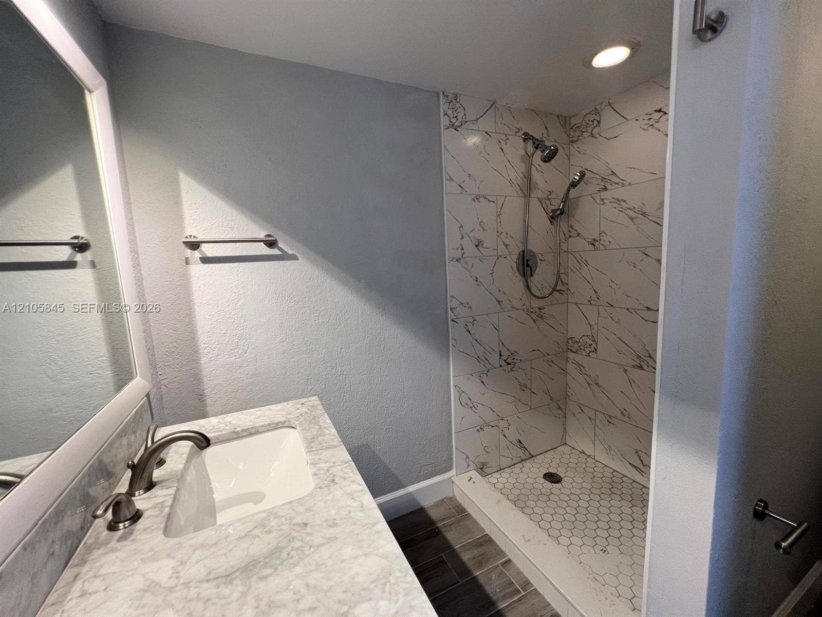 2001 20th Way, #2001, West Palm Beach, West Palm Beach, FL 33407 Bathroom featuring a vanity with a stone-top counter, undermount sink, and metallic faucet, paired with a walk-in shower showcasing large-format wall tile, hexagonal floor tile, and a multi-head shower system