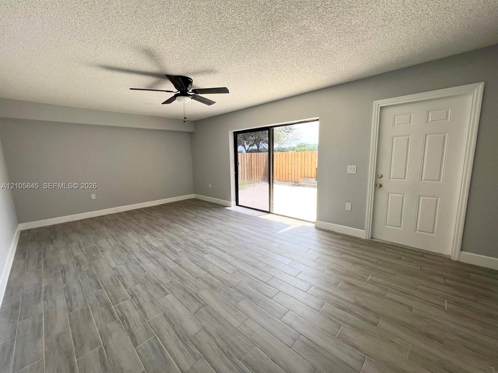 2001 20th Way, #2001, West Palm Beach, West Palm Beach, FL 33407 Wood-finish tile flooring, sliding glass door, ceiling fan, and six-panel door