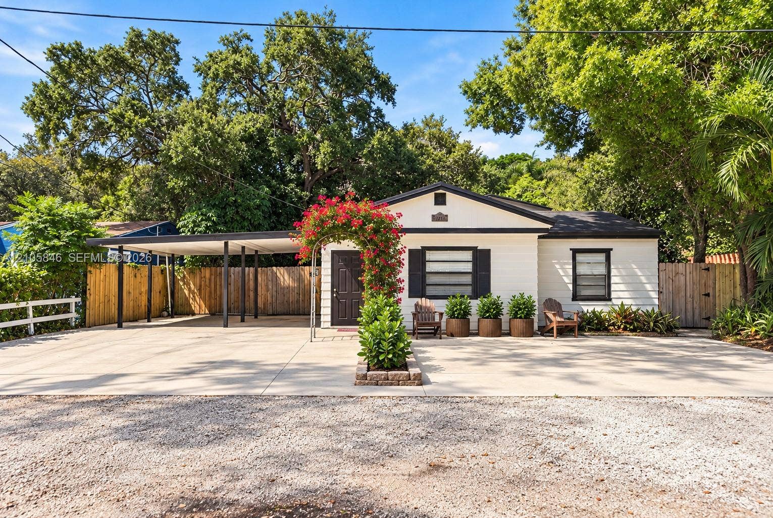 Single-story exterior featuring horizontal siding, a concrete driveway, a covered carport, and decorative window shutters