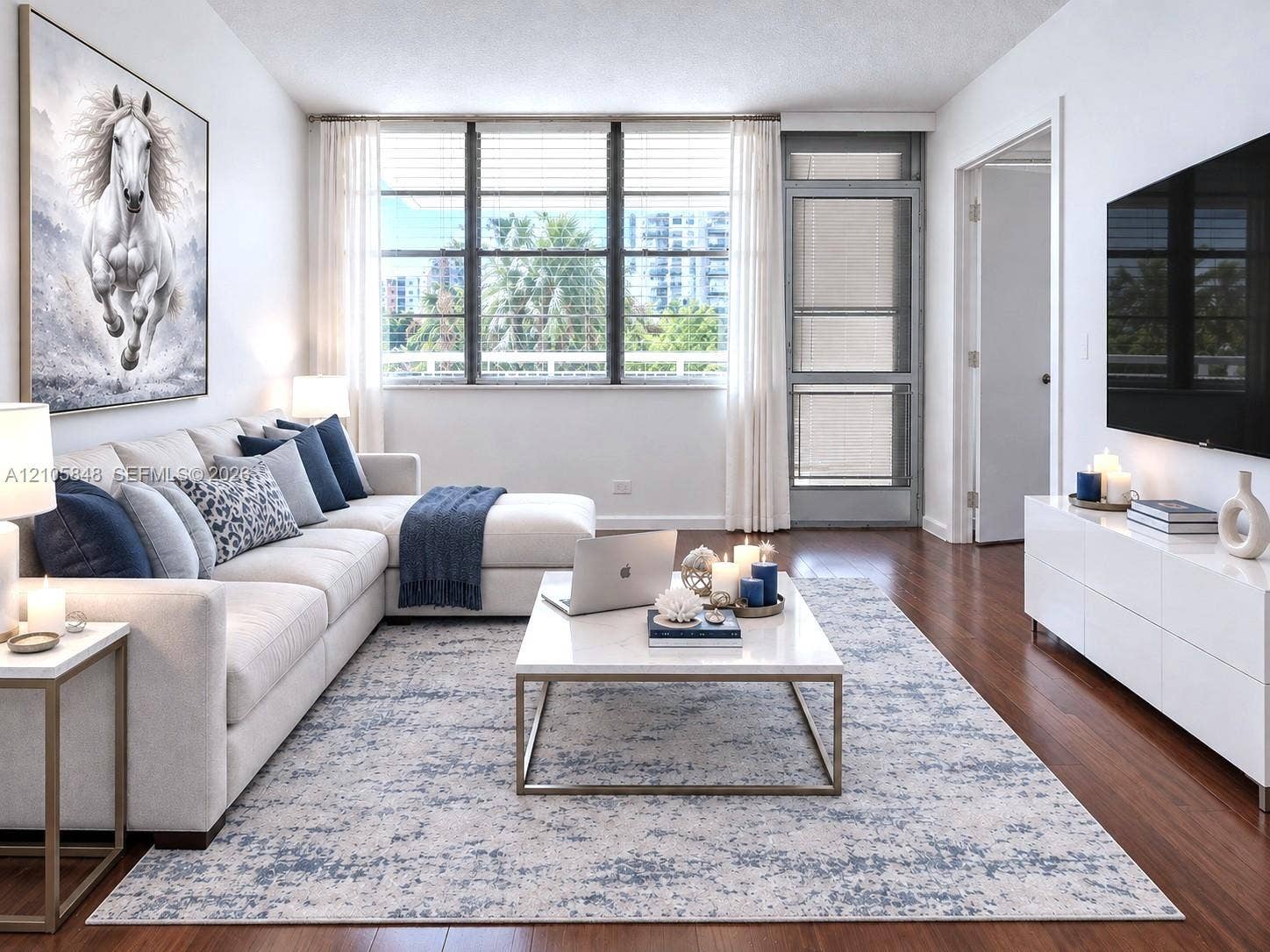 Living area featuring polished wood-finish flooring, large-format multi-pane windows, and a glass-paneled entry door