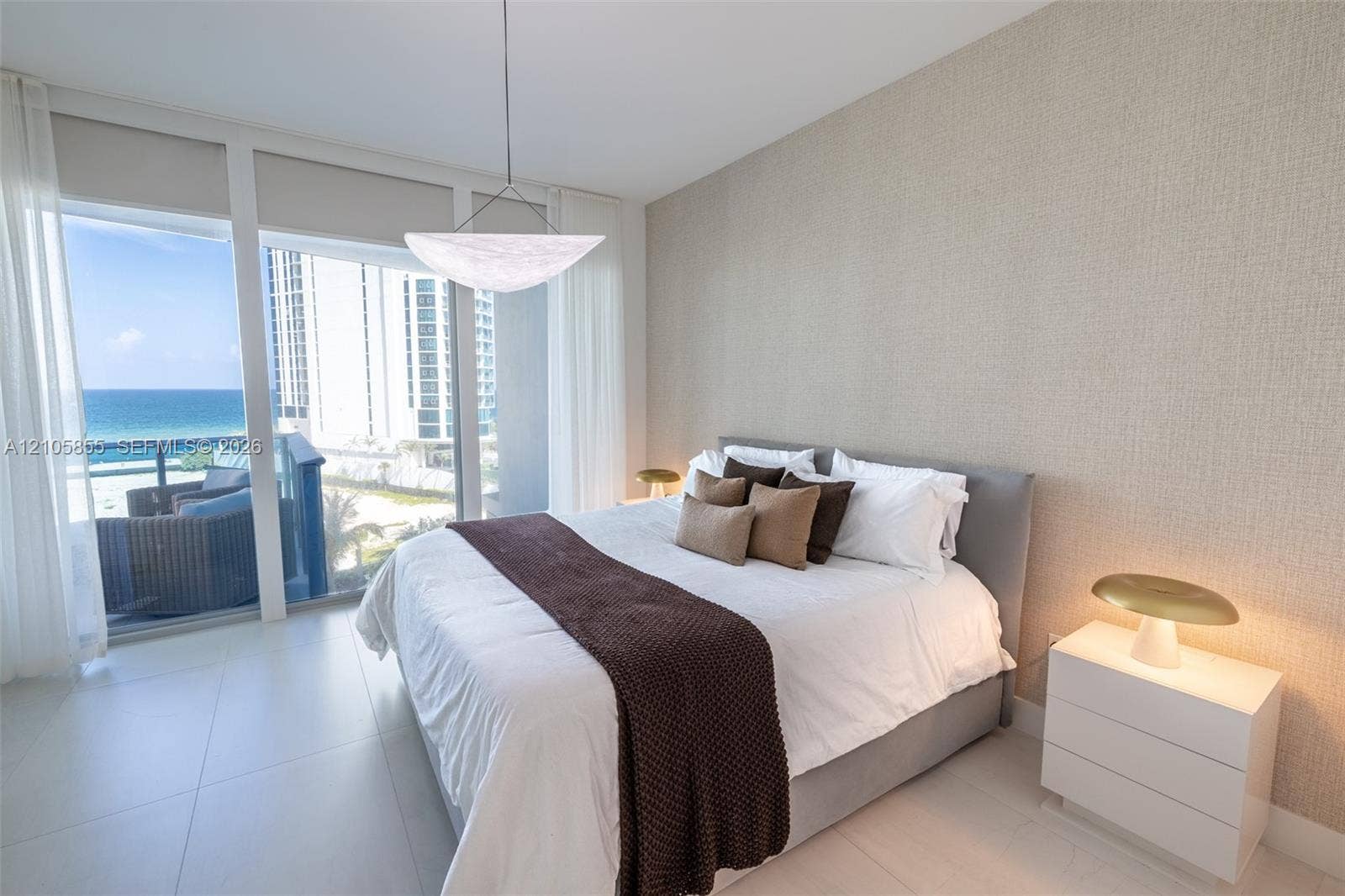 17550 Collins Avenue, #703, Sunny Isles Beach, Sunny Isles Beach, FL 33160 Floor-to-ceiling windows, textured wall covering, large-format tile flooring, modern bowl pendant lighting, and private balcony