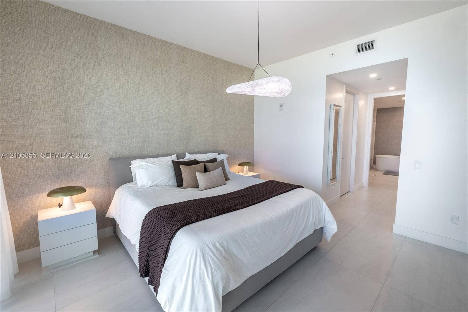17550 Collins Avenue, #703, Sunny Isles Beach, Sunny Isles Beach, FL 33160 Neutral-toned textured accent wall, polished tile flooring, and custom modern pendant lighting fixture