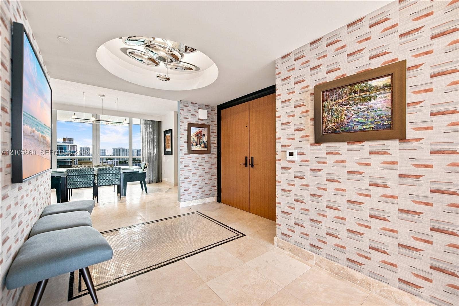 17555 Collins Avenue, #1903, Sunny Isles Beach, FL 33160 Foyer featuring patterned wallpaper, stone tile flooring with a decorative mosaic inlay, recessed circular ceiling detail with multi-bulb lighting, and wood-finish double doors