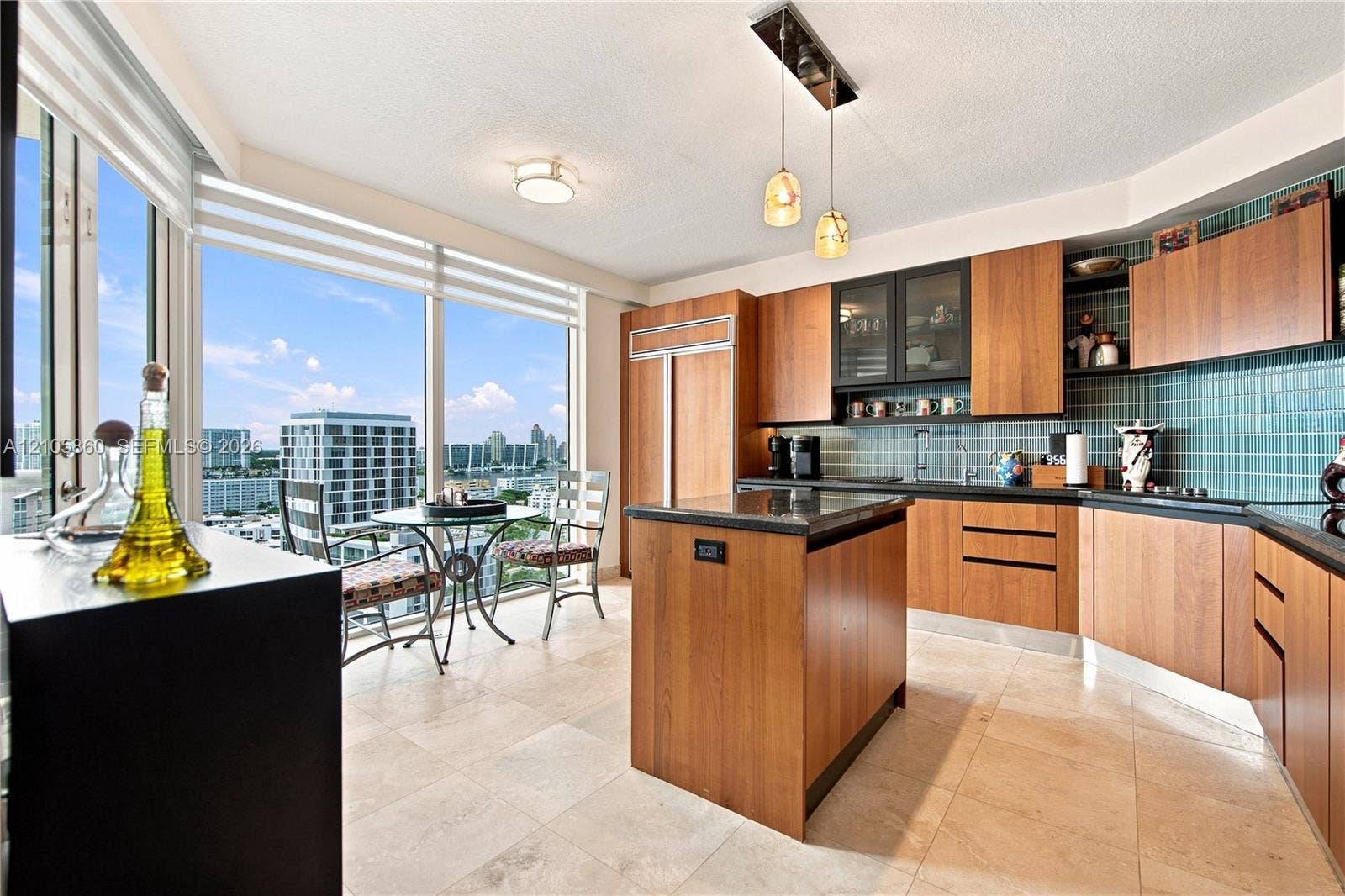 17555 Collins Avenue, #1903, Sunny Isles Beach, FL 33160 Kitchen featuring wood-veneer cabinetry, stone countertops, a central island, tile flooring, and floor-to-ceiling windows