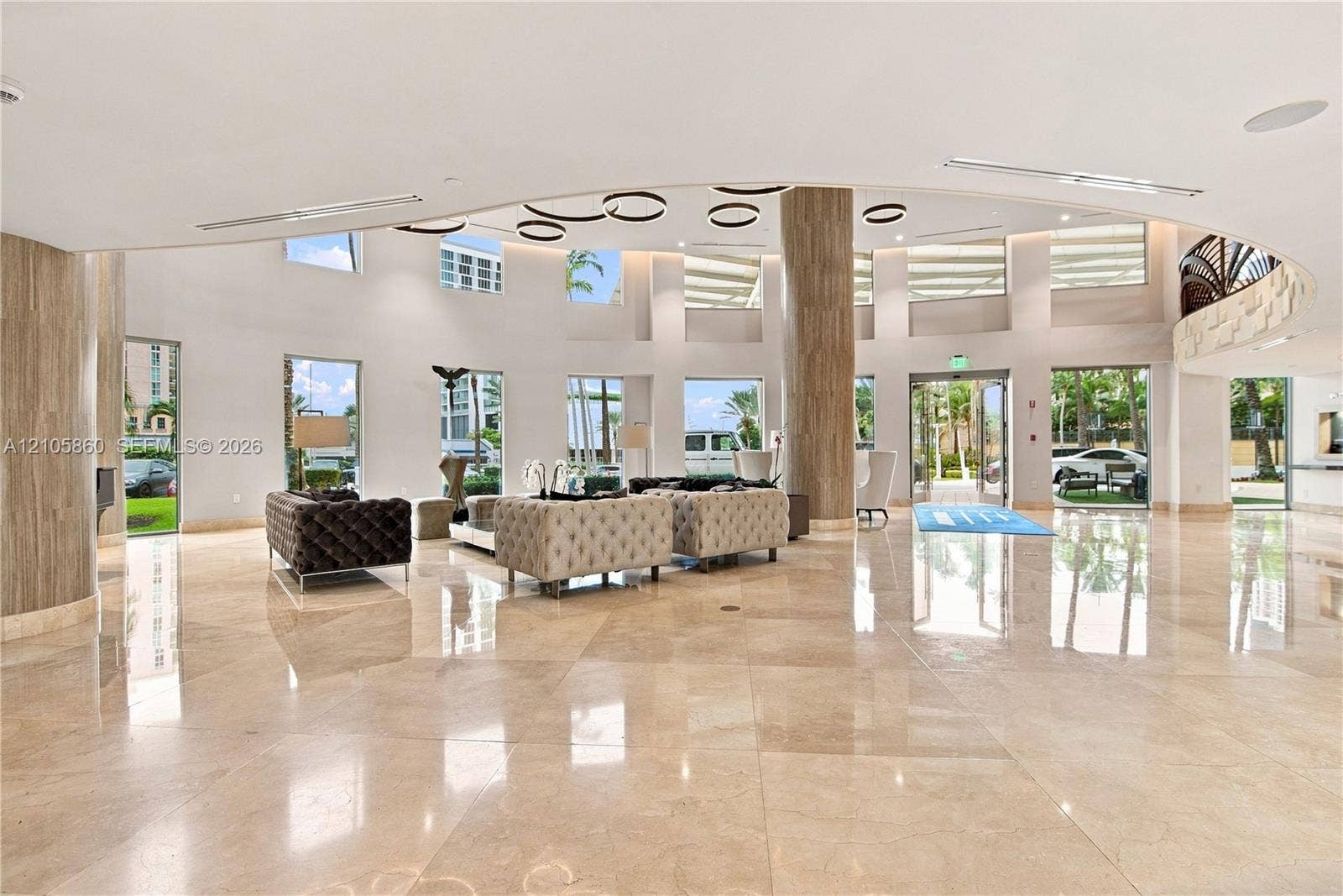17555 Collins Avenue, #1903, Sunny Isles Beach, FL 33160 Expansive lobby featuring polished stone flooring, floor-to-ceiling windows, circular recessed ceiling lighting, and stone-clad support columns