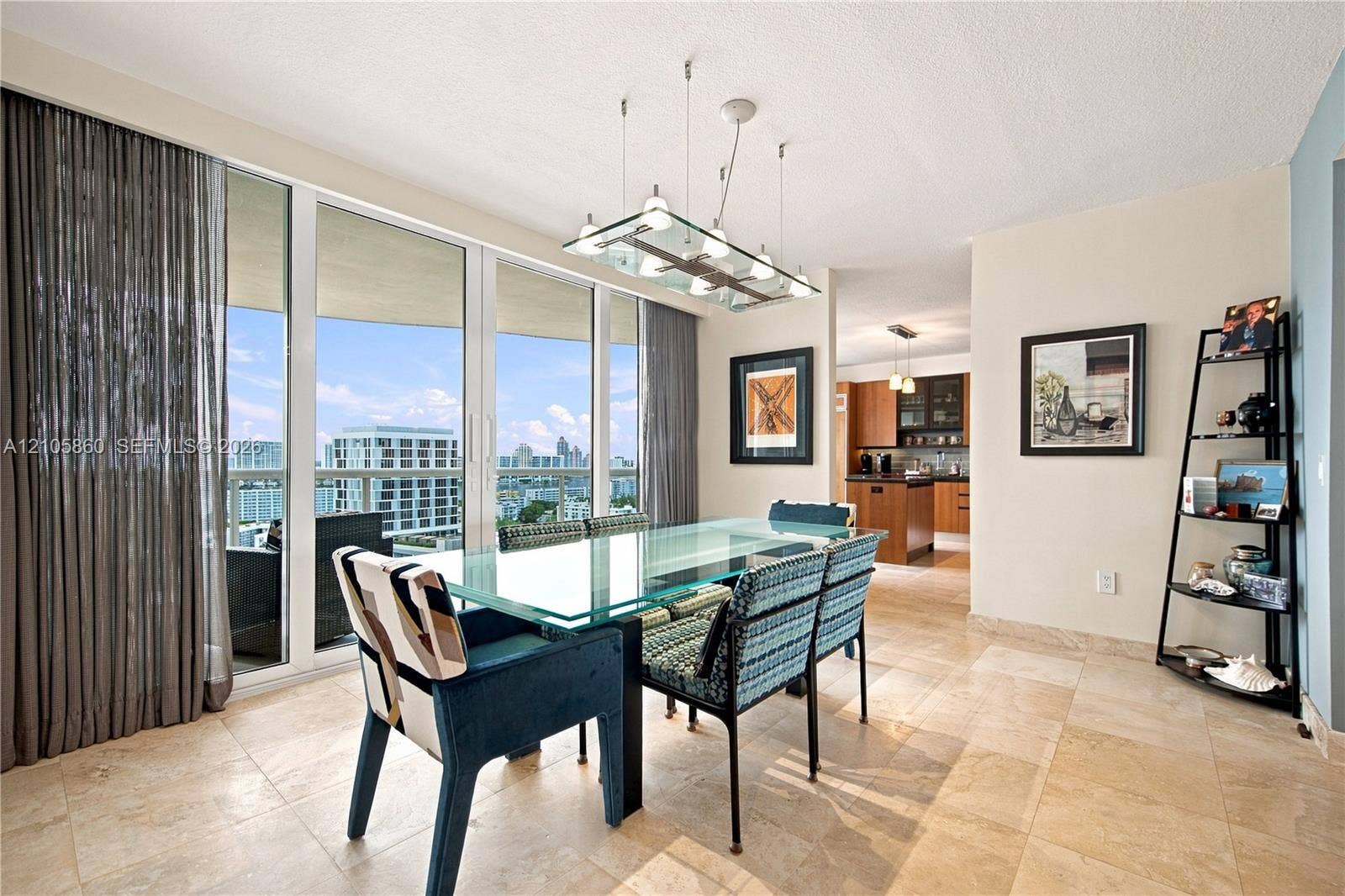 17555 Collins Avenue, #1903, Sunny Isles Beach, FL 33160 Floor-to-ceiling glass panel windows, light-toned stone tile flooring, and a multi-light contemporary pendant fixture