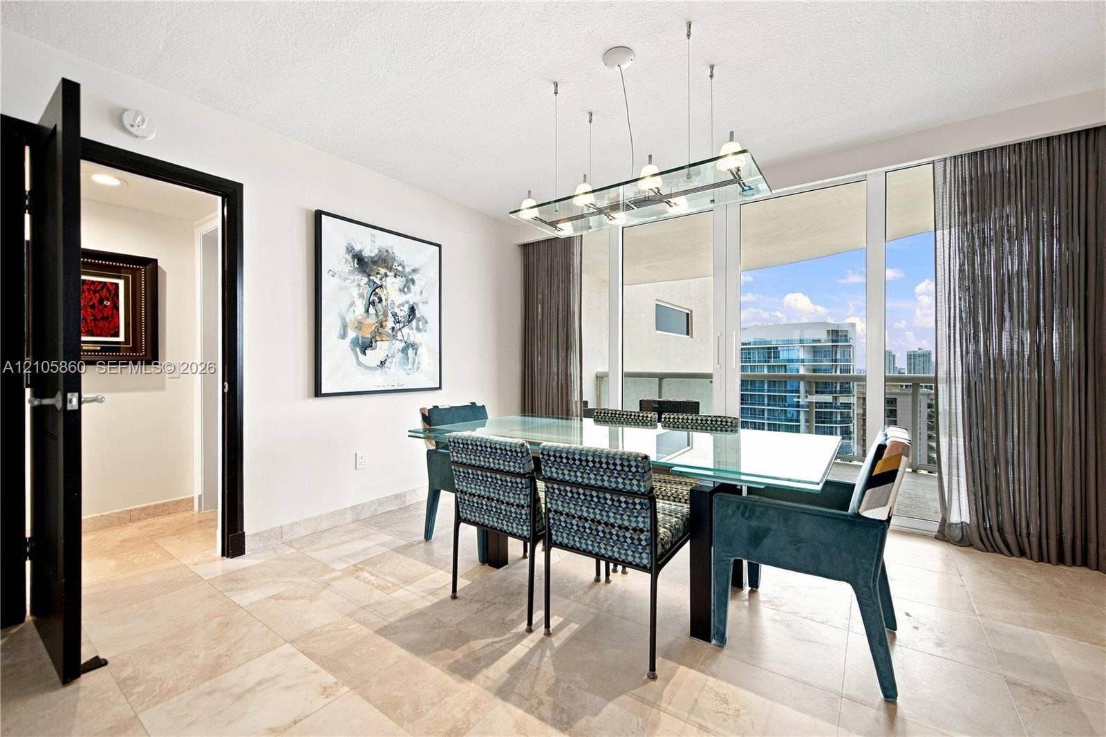 17555 Collins Avenue, #1903, Sunny Isles Beach, FL 33160 Floor-to-ceiling glass paneling, tile flooring, modern multi-light glass chandelier, and black-framed doorway