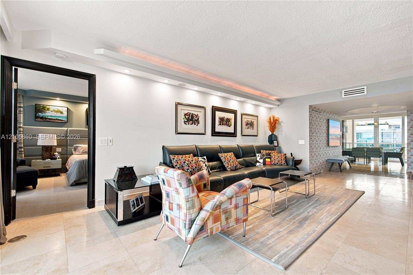 17555 Collins Avenue, #1903, Sunny Isles Beach, FL 33160 Open-concept living area featuring stone tile flooring, built-in cove lighting, and a distinct entryway with high-contrast black trim