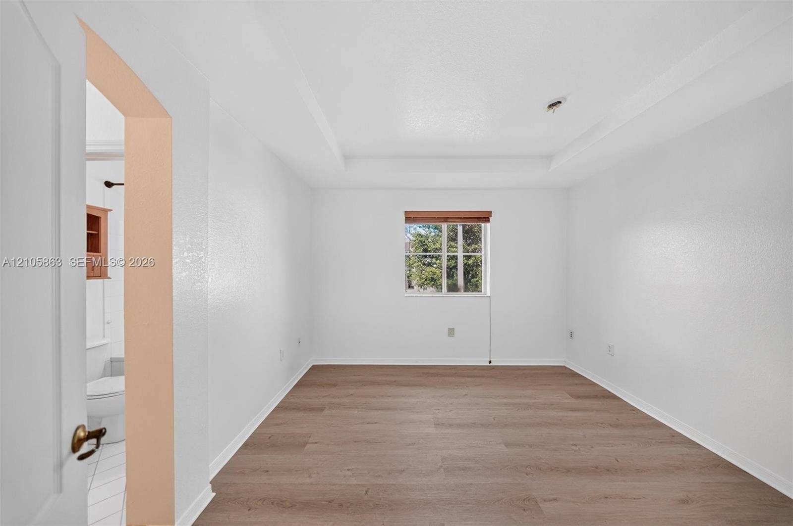8846 W Flagler Street, #5, Miami, FL 33174 Tray ceiling, wood-finish flooring, and single-pane window with wood-trim framing